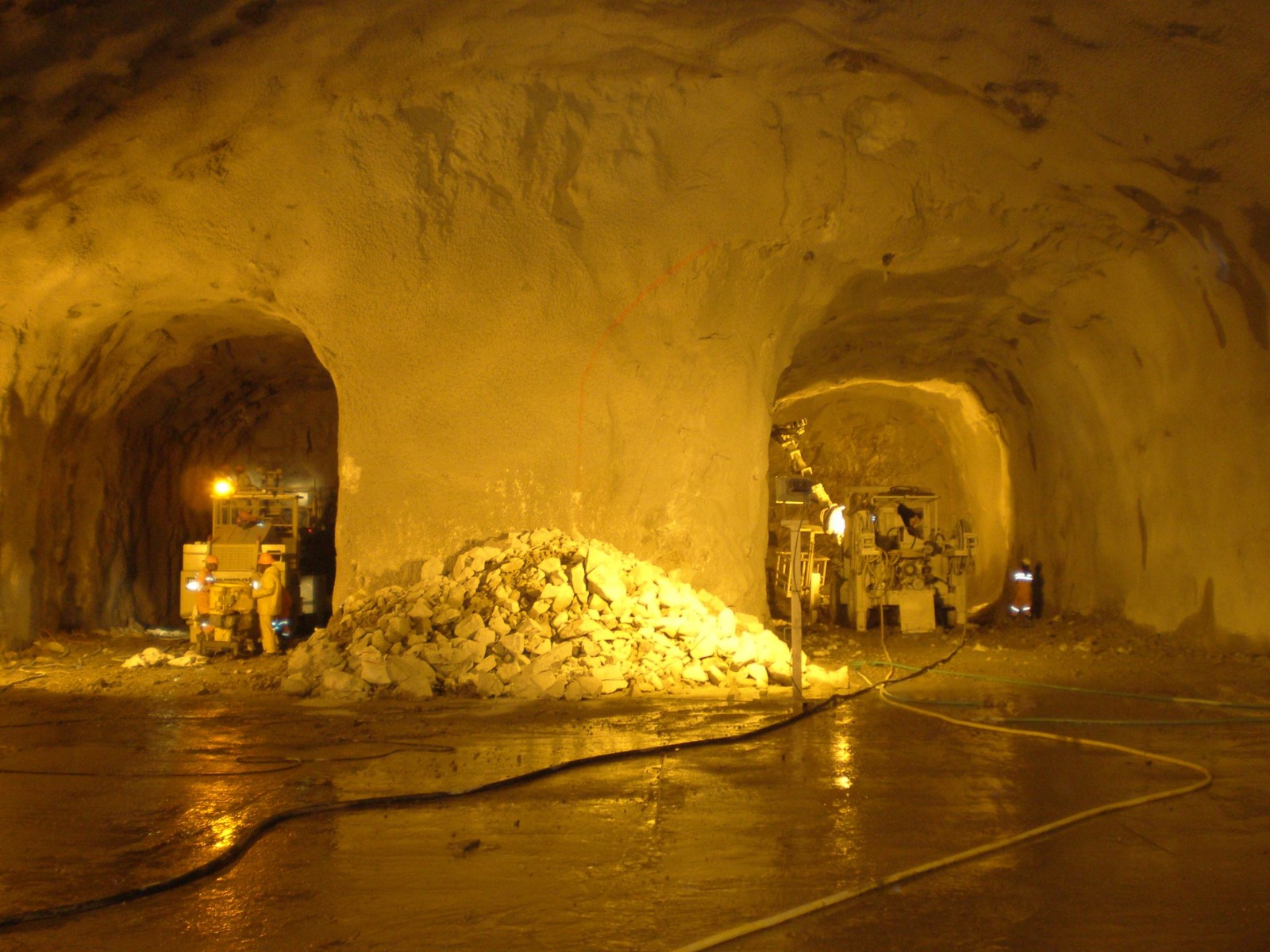 Underground cavern with blasted rock pile and shotcrete walls